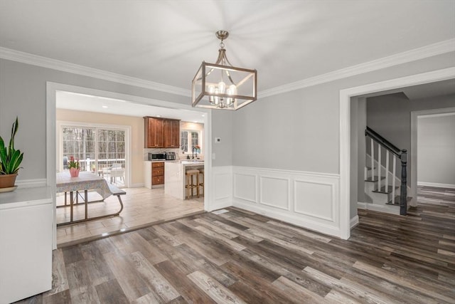 2 Britlees Way, Dudley, MA 01571 - unfurnished dining area featuring a chandelier, wood finished floors, crown molding, and stairs