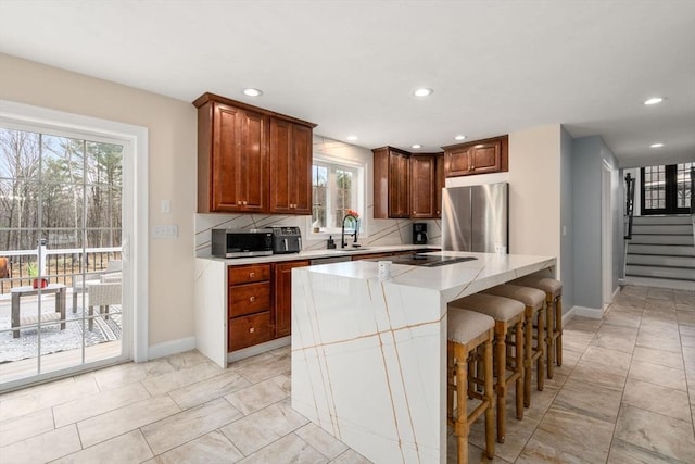 2 Britlees Way, Dudley, MA 01571 - kitchen featuring appliances with stainless steel finishes, plenty of natural light, light countertops, recessed lighting, and a kitchen bar