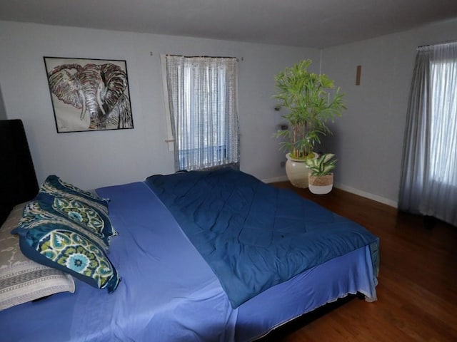 bedroom with dark wood-style floors and baseboards