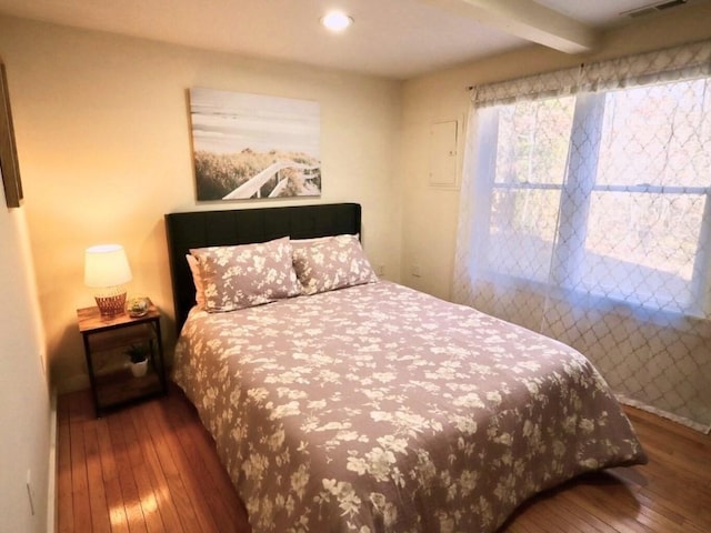 bedroom with dark wood-style flooring and beam ceiling