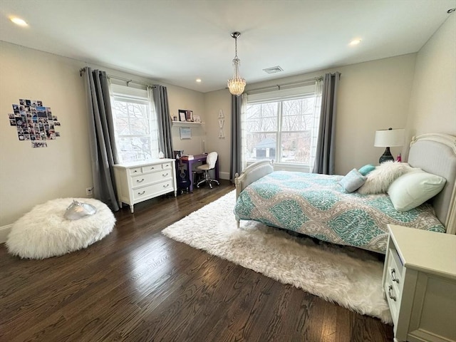 bedroom featuring multiple windows, visible vents, and wood finished floors