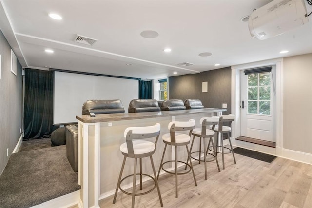 cinema room featuring light wood-type flooring, visible vents, and recessed lighting