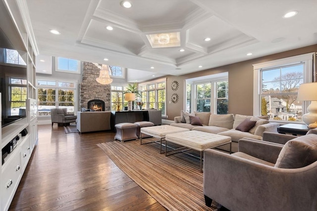 living room with recessed lighting, dark wood-type flooring, a wealth of natural light, and a stone fireplace