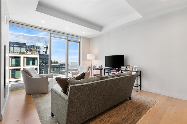 135 Seaport Blvd Unit 1901, Boston, MA 02210 - living room featuring light wood-type flooring, a wall of windows, recessed lighting, and a tray ceiling