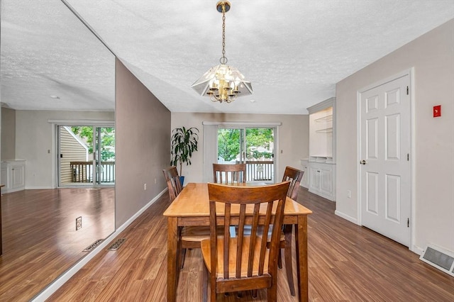 2 Steeplechase Ct Unit 2, Haverhill, MA 01832 - dining room featuring a chandelier, wood finished floors, a textured ceiling, and baseboards