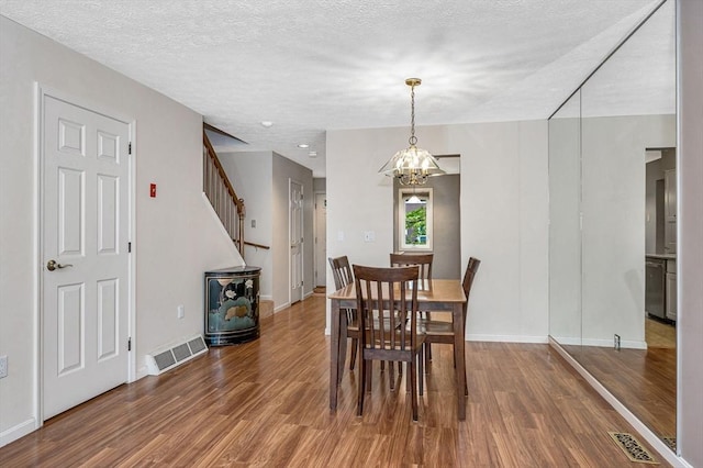 2 Steeplechase Ct Unit 2, Haverhill, MA 01832 - dining space with wood finished floors, a chandelier, stairway, baseboards, and a textured ceiling