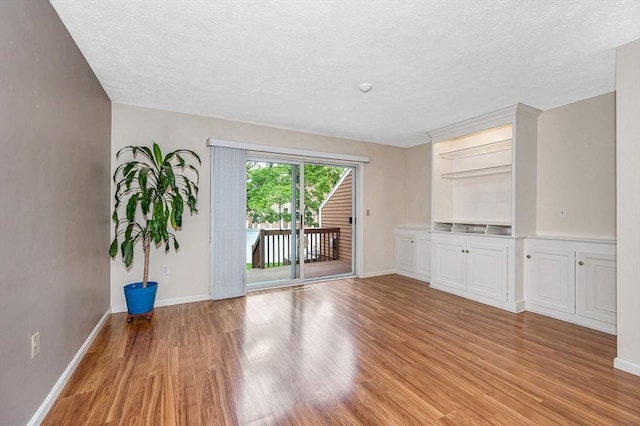 2 Steeplechase Ct Unit 2, Haverhill, MA 01832 - empty room with light wood-style flooring, a textured ceiling, and baseboards