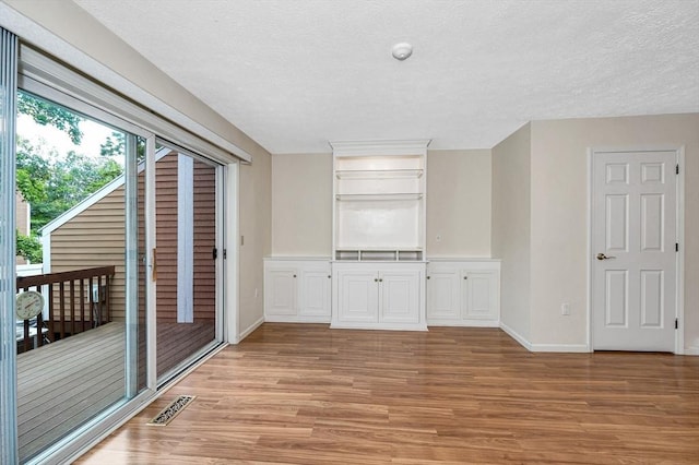 2 Steeplechase Ct Unit 2, Haverhill, MA 01832 - empty room with light wood finished floors, a textured ceiling, and baseboards