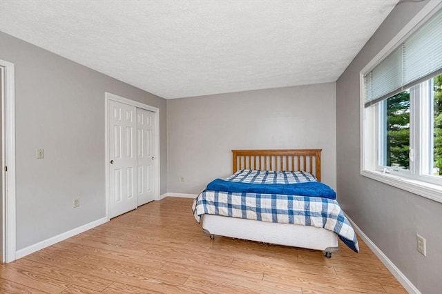 2 Steeplechase Ct Unit 2, Haverhill, MA 01832 - bedroom featuring light wood-style floors, a textured ceiling, baseboards, and a closet