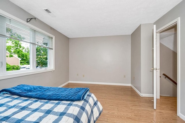 2 Steeplechase Ct Unit 2, Haverhill, MA 01832 - bedroom featuring light wood-type flooring, baseboards, and a textured ceiling