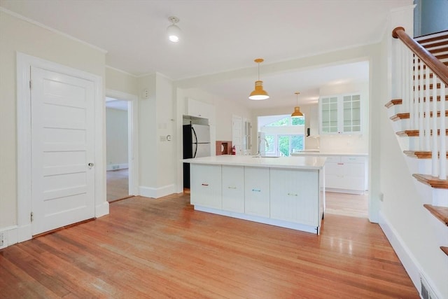 44 Huntington Ave, Sharon, MA 02067 - kitchen with freestanding refrigerator, light wood-style floors, white cabinets, a sink, and light countertops