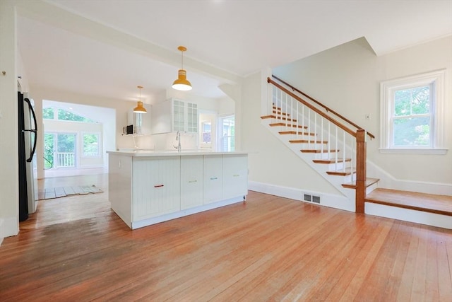 44 Huntington Ave, Sharon, MA 02067 - kitchen featuring freestanding refrigerator, light wood-style floors, white cabinets, and glass insert cabinets
