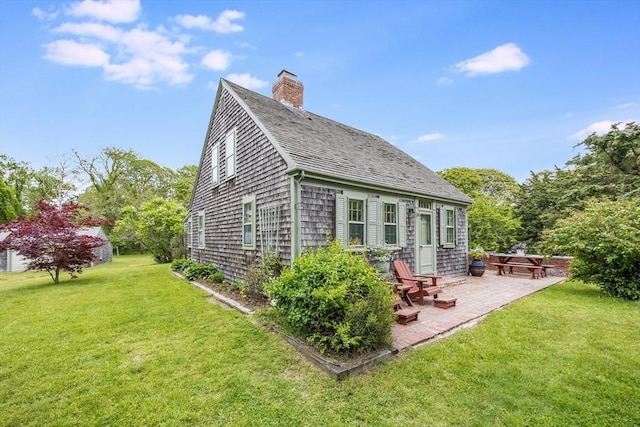 575 Nauset Rd, Eastham, MA 02642 - back of house with a patio, a lawn, a chimney, and a shingled roof
