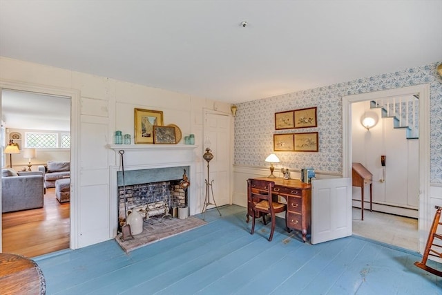 575 Nauset Rd, Eastham, MA 02642 - living room with baseboard heating, wallpapered walls, a fireplace, wood finished floors, and a wainscoted wall