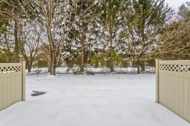 yard covered in snow featuring fence