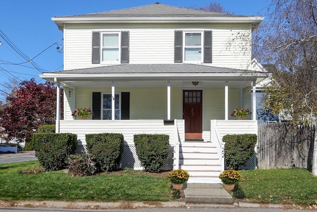 view of front of property featuring roof with shingles, covered porch, stairs, and fence