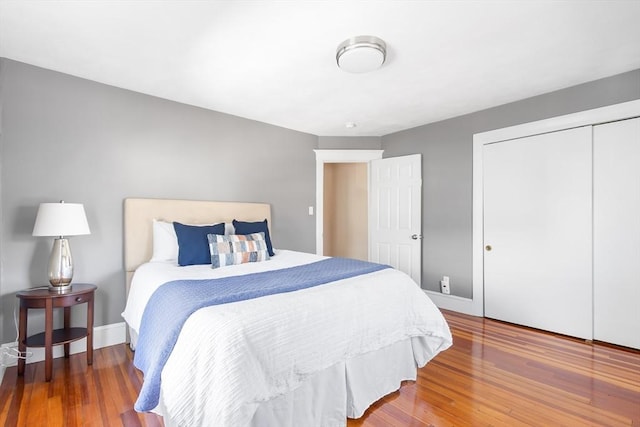 bedroom featuring wood finished floors, a closet, and baseboards