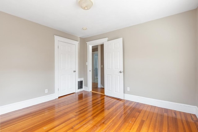 spare room featuring visible vents, baseboards, and light wood-style flooring