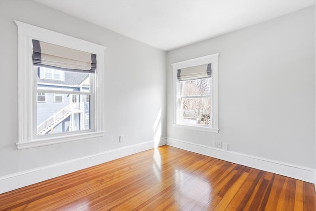 spare room featuring baseboards and wood finished floors