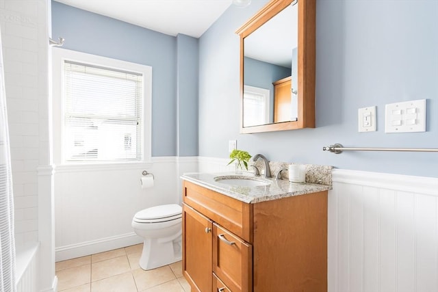 bathroom with vanity, a wainscoted wall, shower / washtub combination, tile patterned floors, and toilet