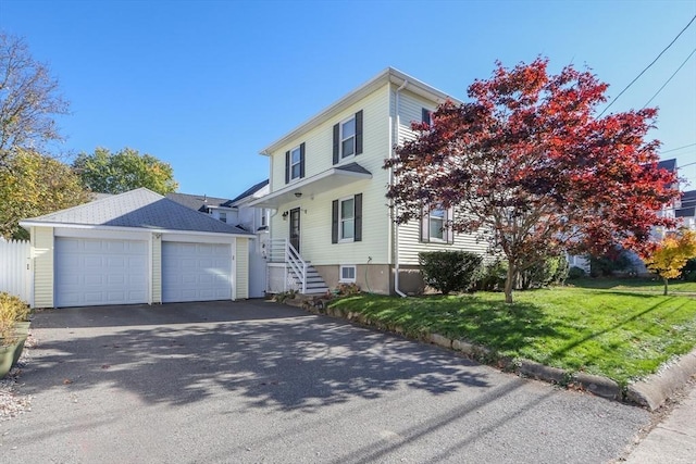 view of front of home with a detached garage and a front yard