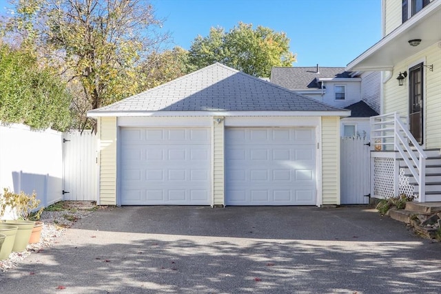 garage with driveway and fence