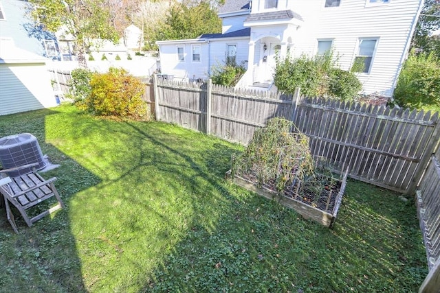 view of yard featuring central air condition unit, a residential view, a vegetable garden, and fence