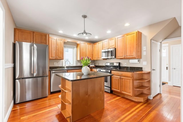 kitchen with light wood-style flooring, open shelves, a sink, dark countertops, and appliances with stainless steel finishes