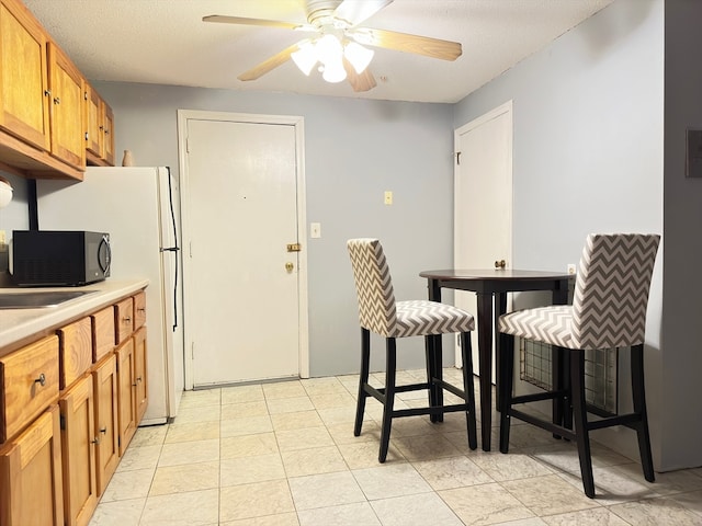 kitchen featuring ceiling fan and a textured ceiling