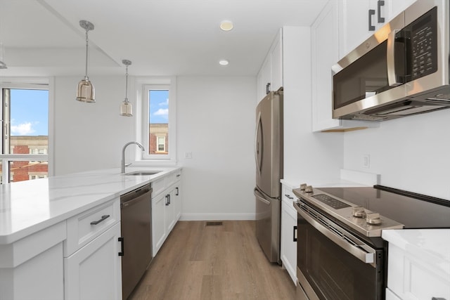 kitchen featuring white cabinets, appliances with stainless steel finishes, and a healthy amount of sunlight