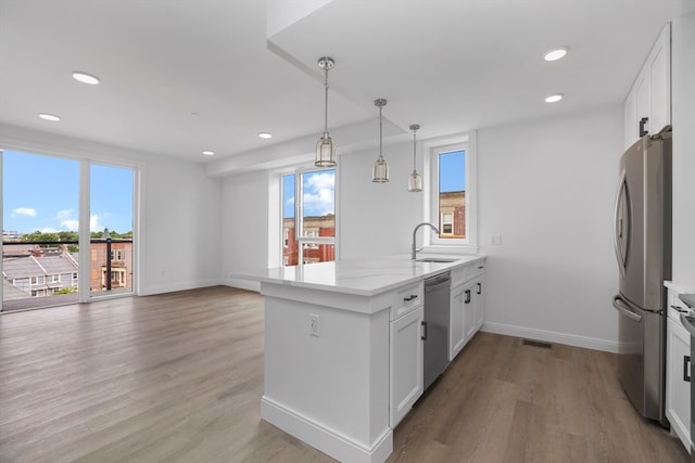 kitchen with light hardwood / wood-style floors, plenty of natural light, stainless steel appliances, and white cabinets