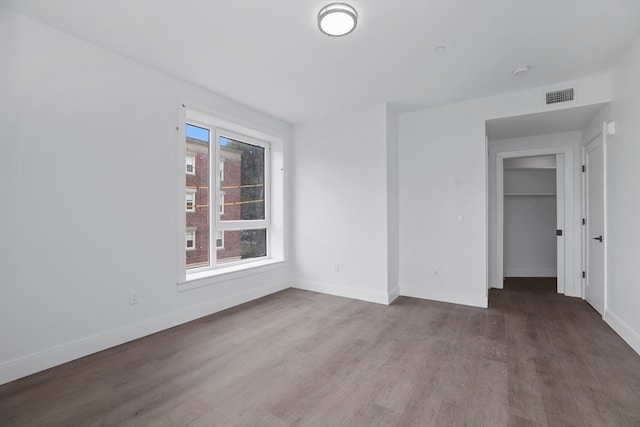 unfurnished bedroom with dark hardwood / wood-style floors and a closet