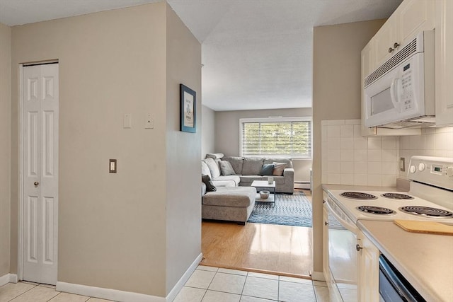 45 Macy St Unit B-205, Amesbury, MA 01913 - kitchen with white appliances, white cabinets, light tile patterned floors, light countertops, and a baseboard heating unit