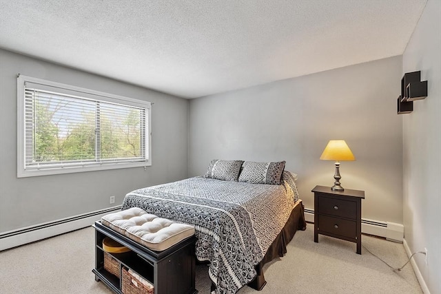 45 Macy St Unit B-205, Amesbury, MA 01913 - bedroom featuring light carpet, a baseboard heating unit, baseboards, and a textured ceiling