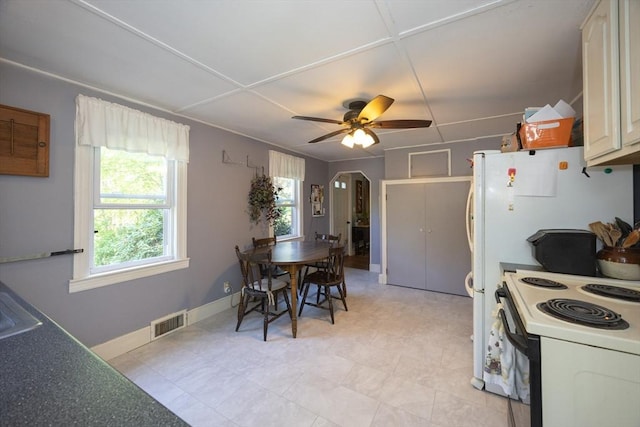 kitchen with arched walkways, white electric range oven, ceiling fan, and baseboards