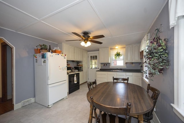 kitchen with freestanding refrigerator, black / electric stove, a sink, stainless steel microwave, and ceiling fan