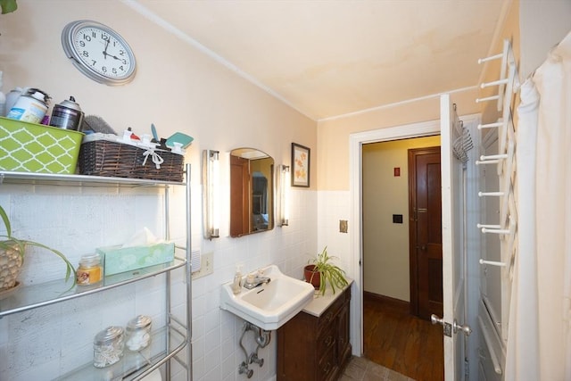 bathroom with tile walls, a sink, and wood finished floors