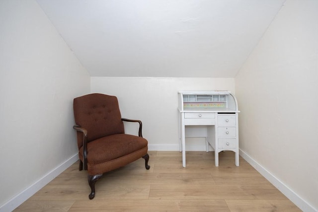 sitting room featuring light wood-type flooring, baseboards, and vaulted ceiling