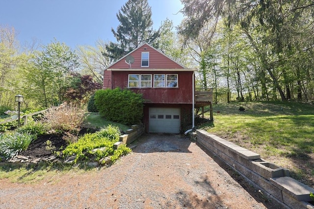 view of side of home featuring driveway, an attached garage, and a lawn