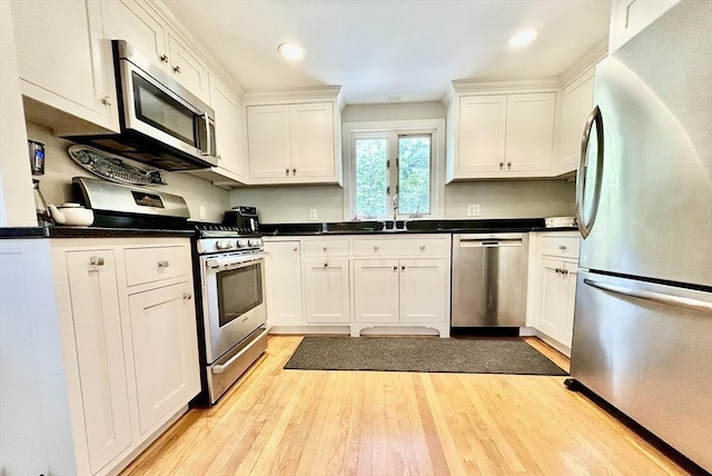 53 Washington St, Topsfield, MA 01983 - kitchen featuring appliances with stainless steel finishes, white cabinets, light wood-style floors, dark countertops, and recessed lighting