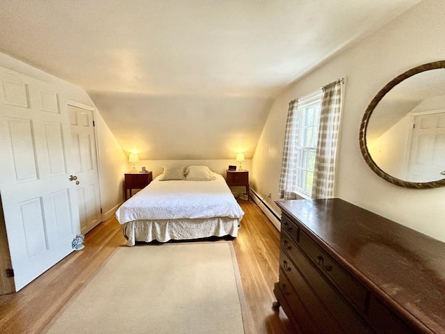 53 Washington St, Topsfield, MA 01983 - bedroom with a baseboard heating unit, light wood-style floors, and vaulted ceiling