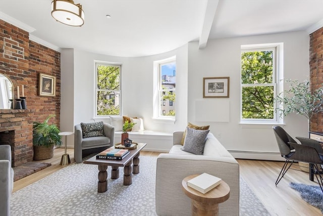 living area with wood finished floors, beam ceiling, baseboards, a brick fireplace, and brick wall