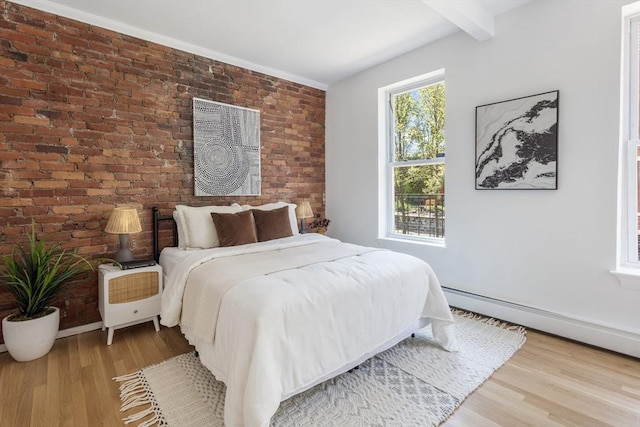 bedroom featuring wood finished floors, brick wall, beam ceiling, a baseboard radiator, and baseboards