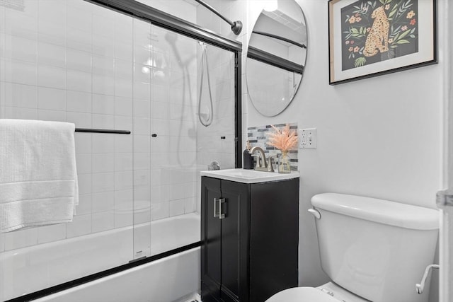 bathroom with toilet, combined bath / shower with glass door, and vanity