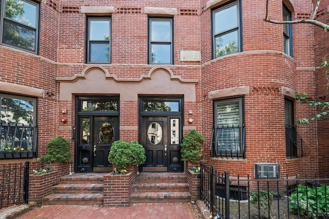 property entrance featuring brick siding and fence