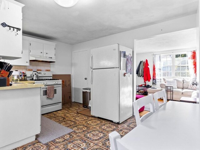 84 Lancaster Rd Unit 84, Dedham, MA 02026 - kitchen featuring white appliances, tasteful backsplash, white cabinetry, under cabinet range hood, and light countertops