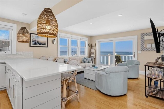 14 Stanton Ln, Scituate, MA 02066 - kitchen featuring a breakfast bar, open floor plan, light wood-style floors, healthy amount of natural light, and recessed lighting