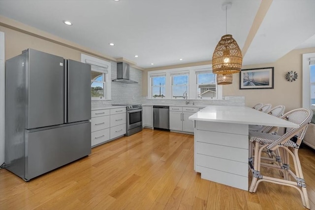 14 Stanton Ln, Scituate, MA 02066 - kitchen with appliances with stainless steel finishes, wall chimney exhaust hood, a peninsula, light countertops, and light wood-style flooring