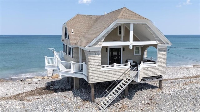 14 Stanton Ln, Scituate, MA 02066 - view of front of house with view of water and beach, a porch, and a shingled roof