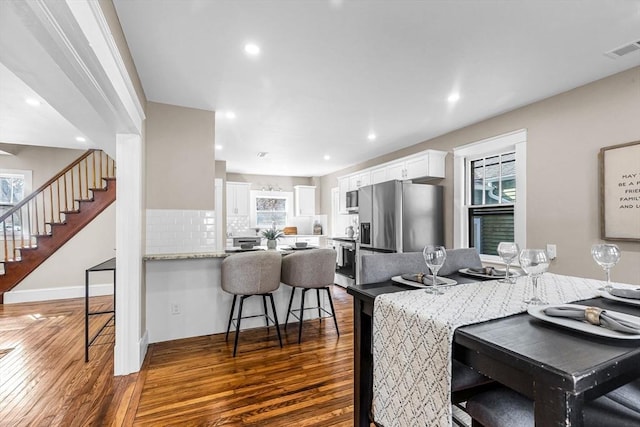 dining area with plenty of natural light, visible vents, and dark wood finished floors